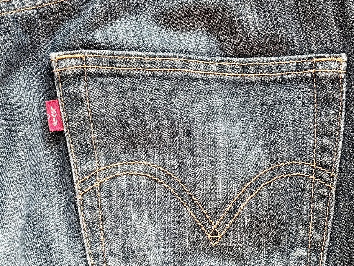 Back pocket of a pair of Levi's 501 jeans showing the arcuate stitching and the red Tab